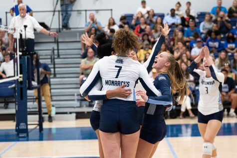 The Lady Monarchs celebrate after securing a set victory 