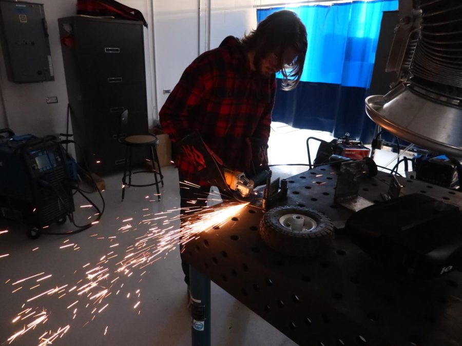 Linkel demonstrating the use of an angle grinder.