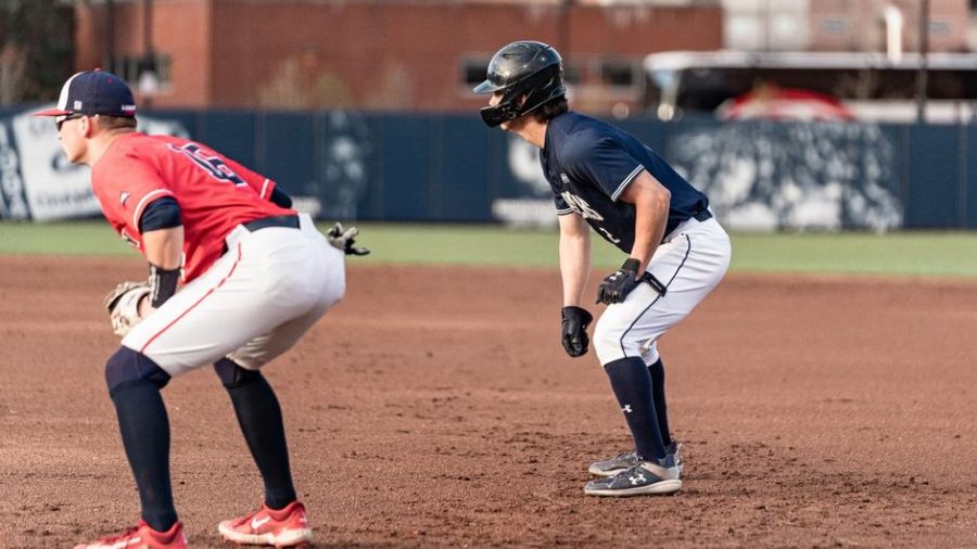 Sophomore+Luke+Waters+takes+his+lead+off+of+first+base+while+looking+on+at+the+at-bat.