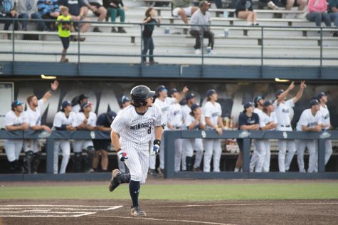 Freshman Alex Bouche looks on as his teammates react to the home run shot down left-field in game one against Coastal.