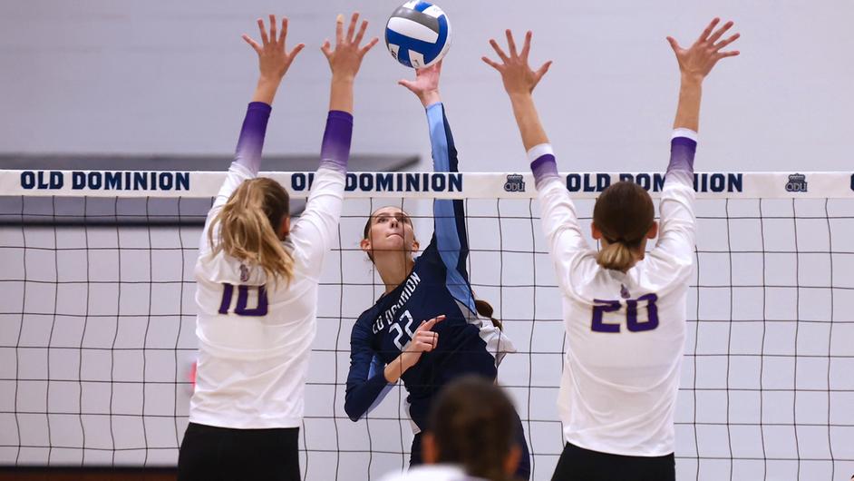 Junior Myah Conway makes an attempt to hit the ball past the Dukes defenders at the net.