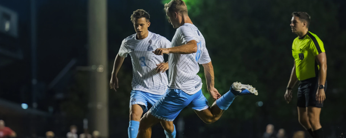 Graduate midfielder Andrew Bennett goes in for the free kick, taken earlier this season. 