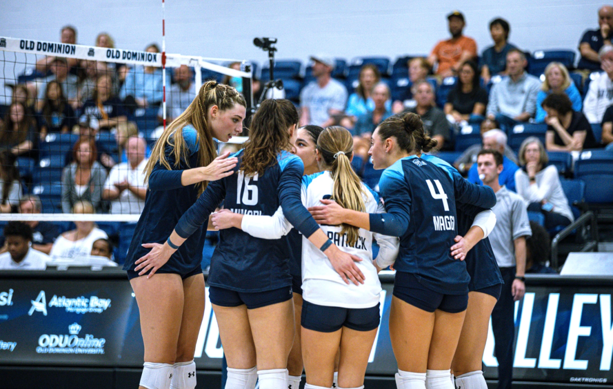 Lady Monarchs come together after scoring point against Mountaineers. 