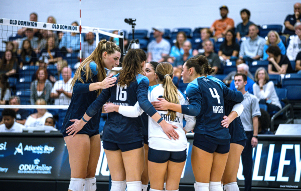 Lady Monarchs come together after scoring point against Mountaineers. 