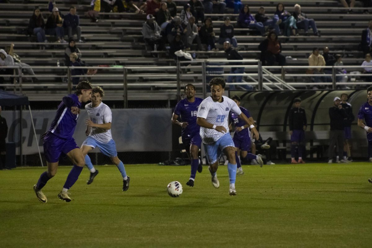 Graduate forward Noah Madrigal plays the ball in contest against the Dukes. 